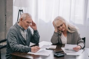 A retired couple going over their monthly spending to see where they’re overspending.