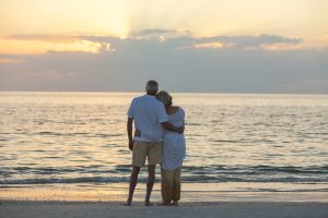 A retired couple enjoying a beachside vacation sunset.